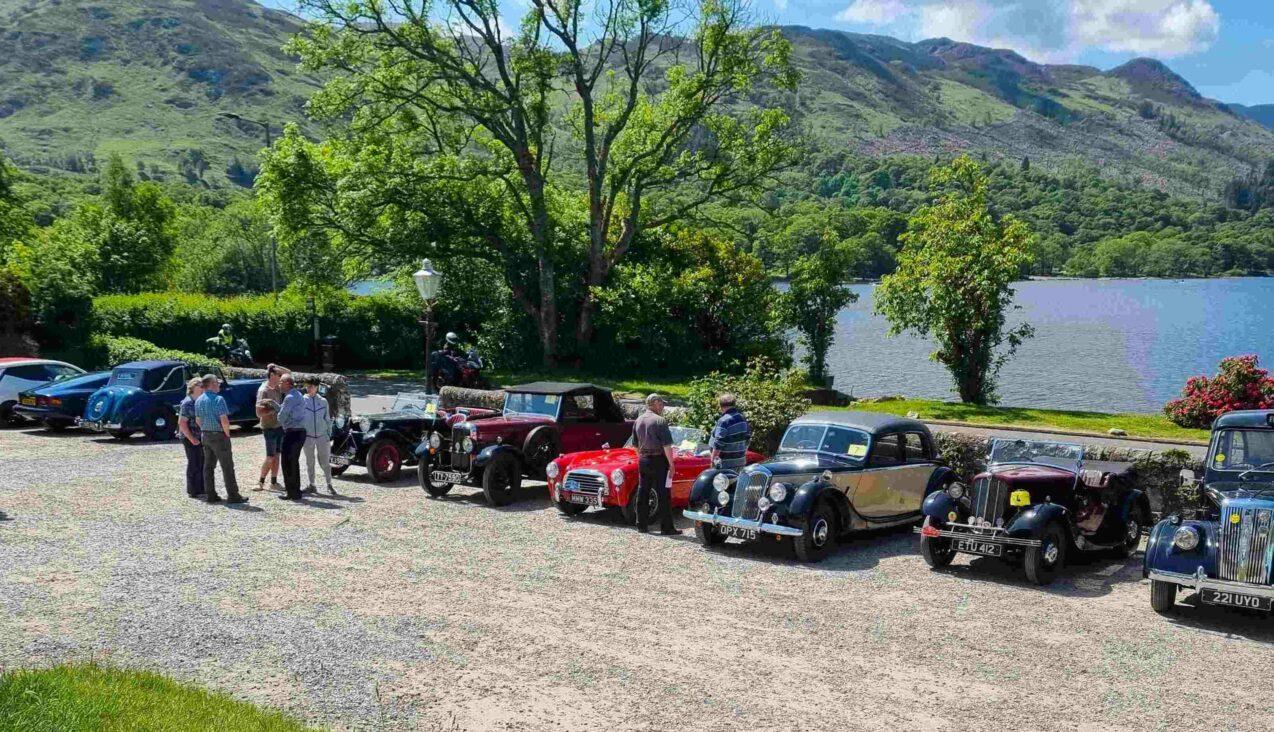 A rally of classic cars on the hotel forecourt above the loch